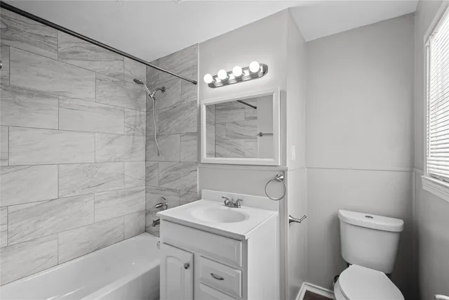 a bathroom with a granite countertop sink a toilet and shower