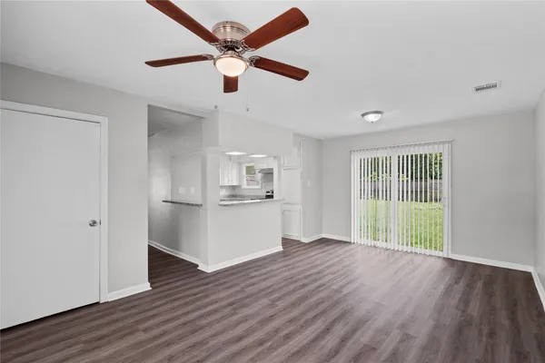 a view of a kitchen with wooden floor and a ceiling fan