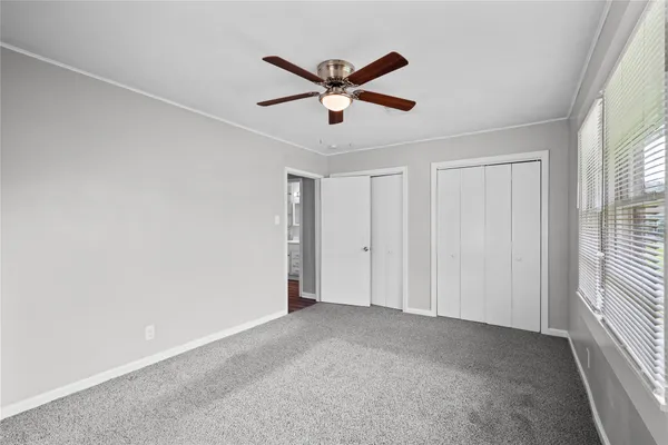 a view of an empty room with a ceiling fan
