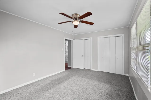 a view of an empty room with a ceiling fan