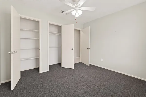 a view of an empty room with a ceiling fan
