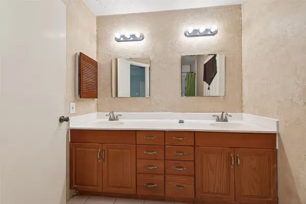 a bathroom with double sink and two mirror