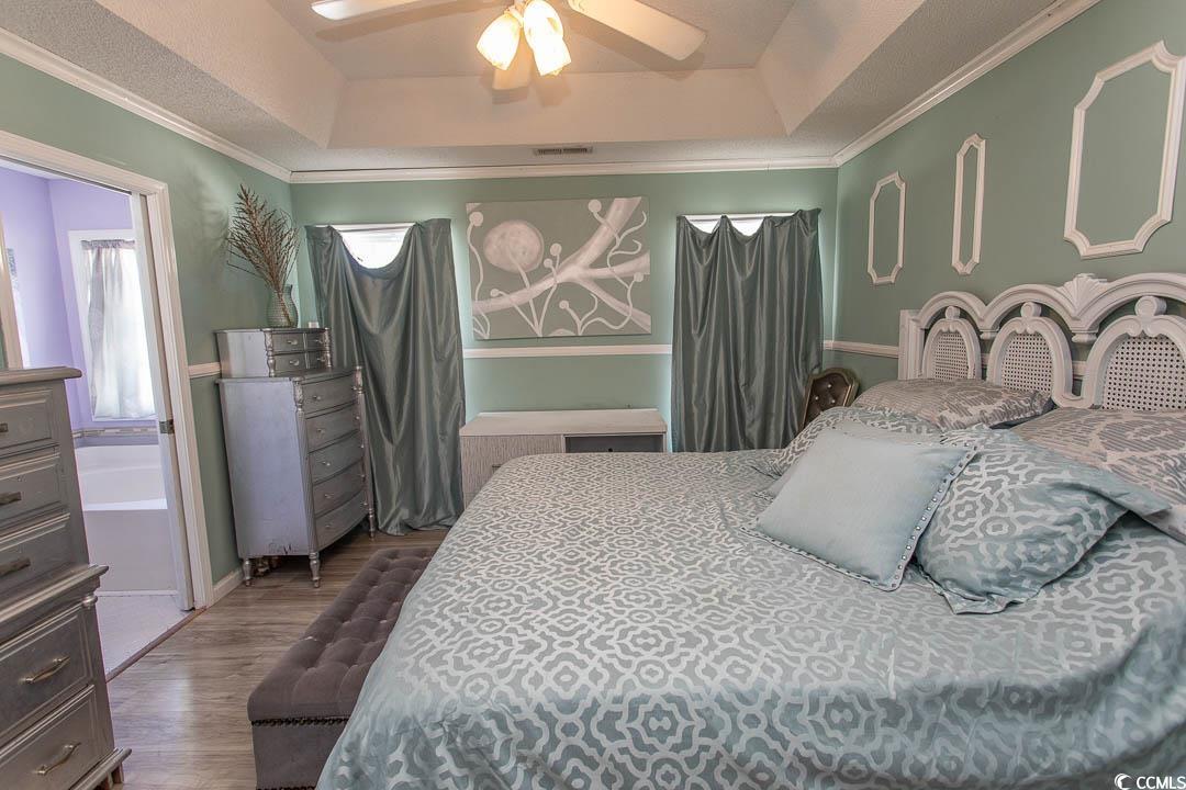 761 Drawbridge Drive Conway, SC 29526 - Photo 11 of 36 Bedroom featuring ornamental molding, wood finished floors, a ceiling fan, and a raised ceiling