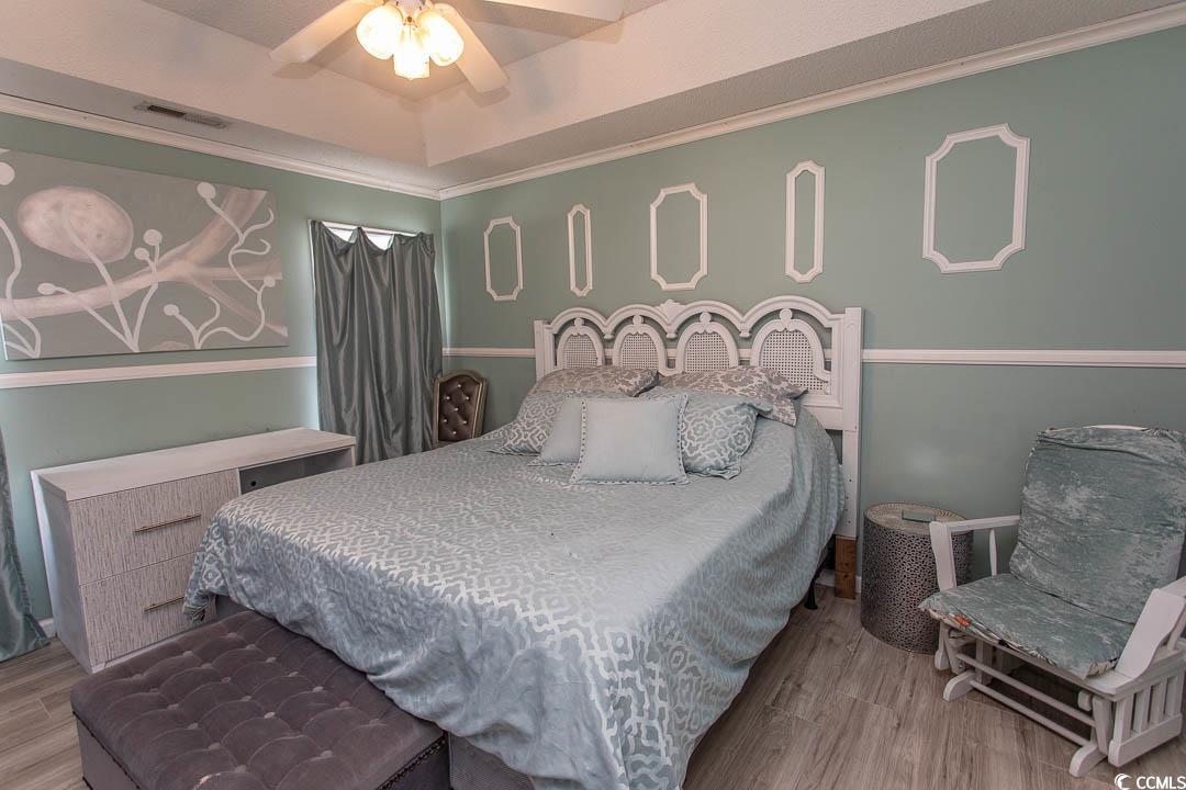 761 Drawbridge Drive Conway, SC 29526 - Photo 12 of 36 Bedroom featuring crown molding, wood finished floors, a ceiling fan, and a raised ceiling