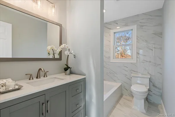 a bathroom with a toilet sink and mirror