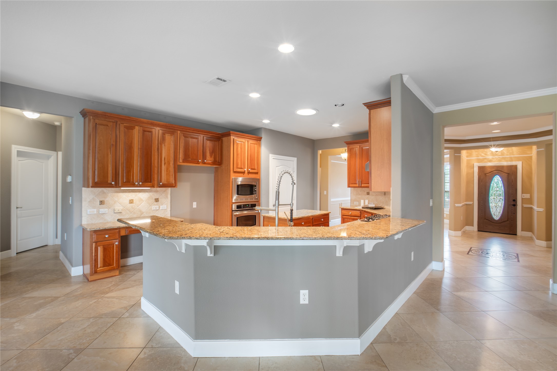 214 Summit Street Georgetown, TX 78633 - Photo 11 of 38 Well-appointed kitchen featuring wood cabinetry, granite countertops, stainless steel appliances, and a tiled backsplash
