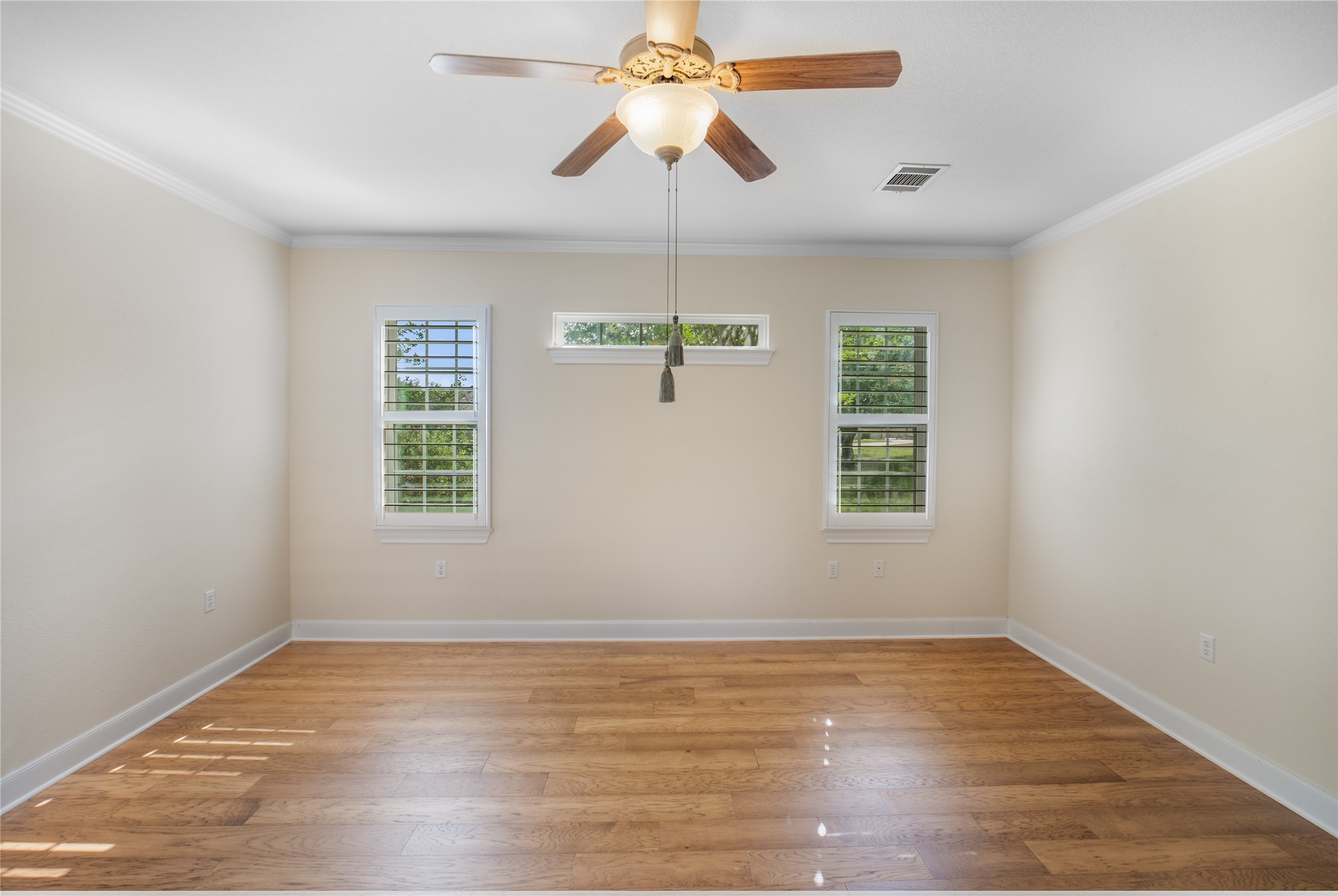 214 Summit Street Georgetown, TX 78633 - Photo 22 of 38 This room features wood flooring, crown molding, and a ceiling fan with integrated lighting