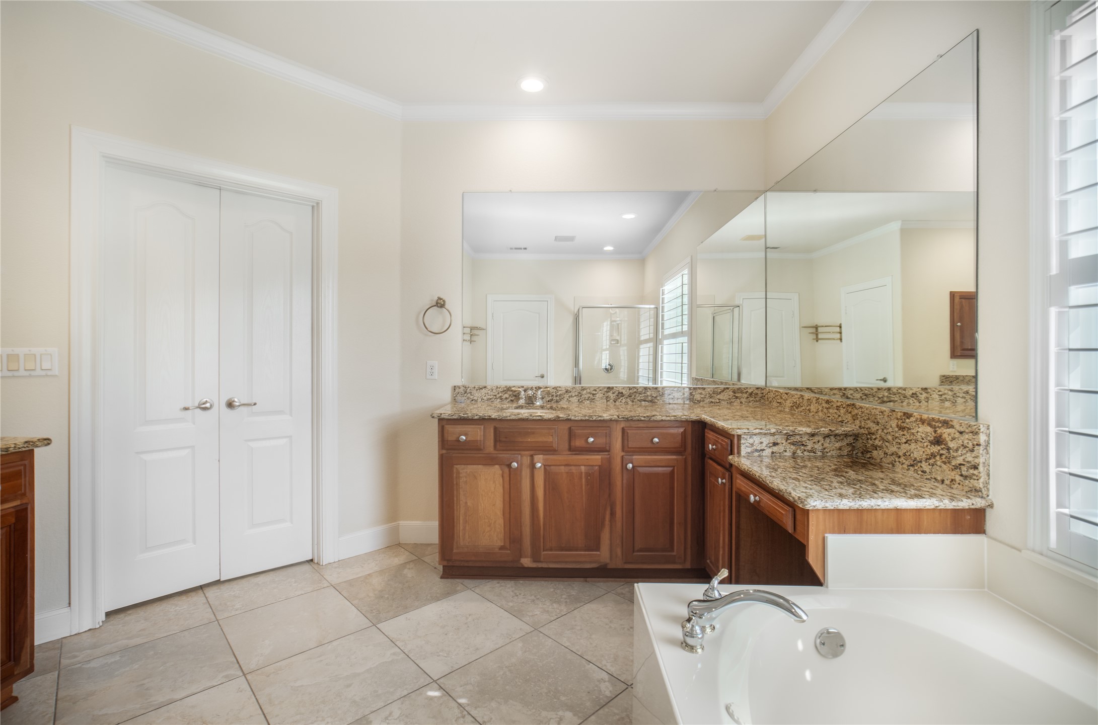 214 Summit Street Georgetown, TX 78633 - Photo 23 of 38 Bathroom featuring light-colored tile flooring, a large soaking tub with a chrome faucet, and a vanity with granite countertops and wood cabinetry
