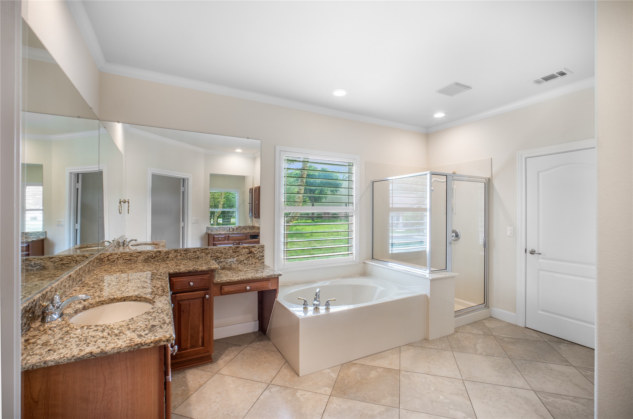 214 Summit Street Georgetown, TX 78633 - Photo 24 of 38 This bathroom features a large soaking tub, a separate glass-enclosed shower, and a vanity with a granite countertop and a built-in sink