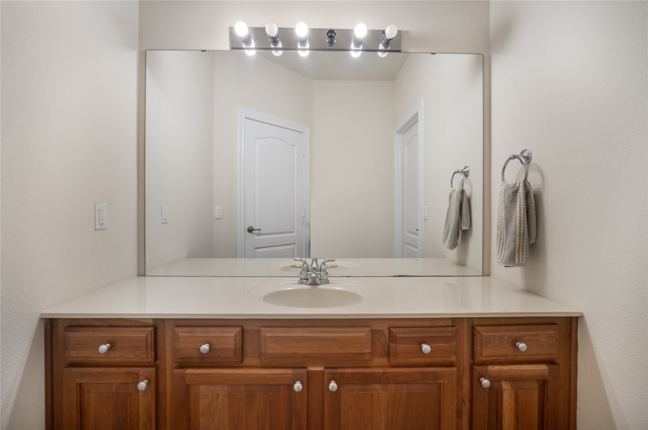 214 Summit Street Georgetown, TX 78633 - Photo 27 of 38 The bathroom features a light-colored countertop, a chrome faucet, and a large mirror with overhead lighting