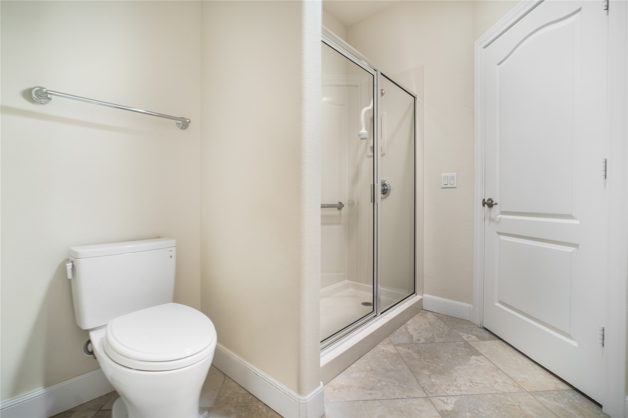 214 Summit Street Georgetown, TX 78633 - Photo 28 of 38 Bathroom featuring a glass-enclosed shower, a white toilet, a chrome towel bar, and tiled flooring