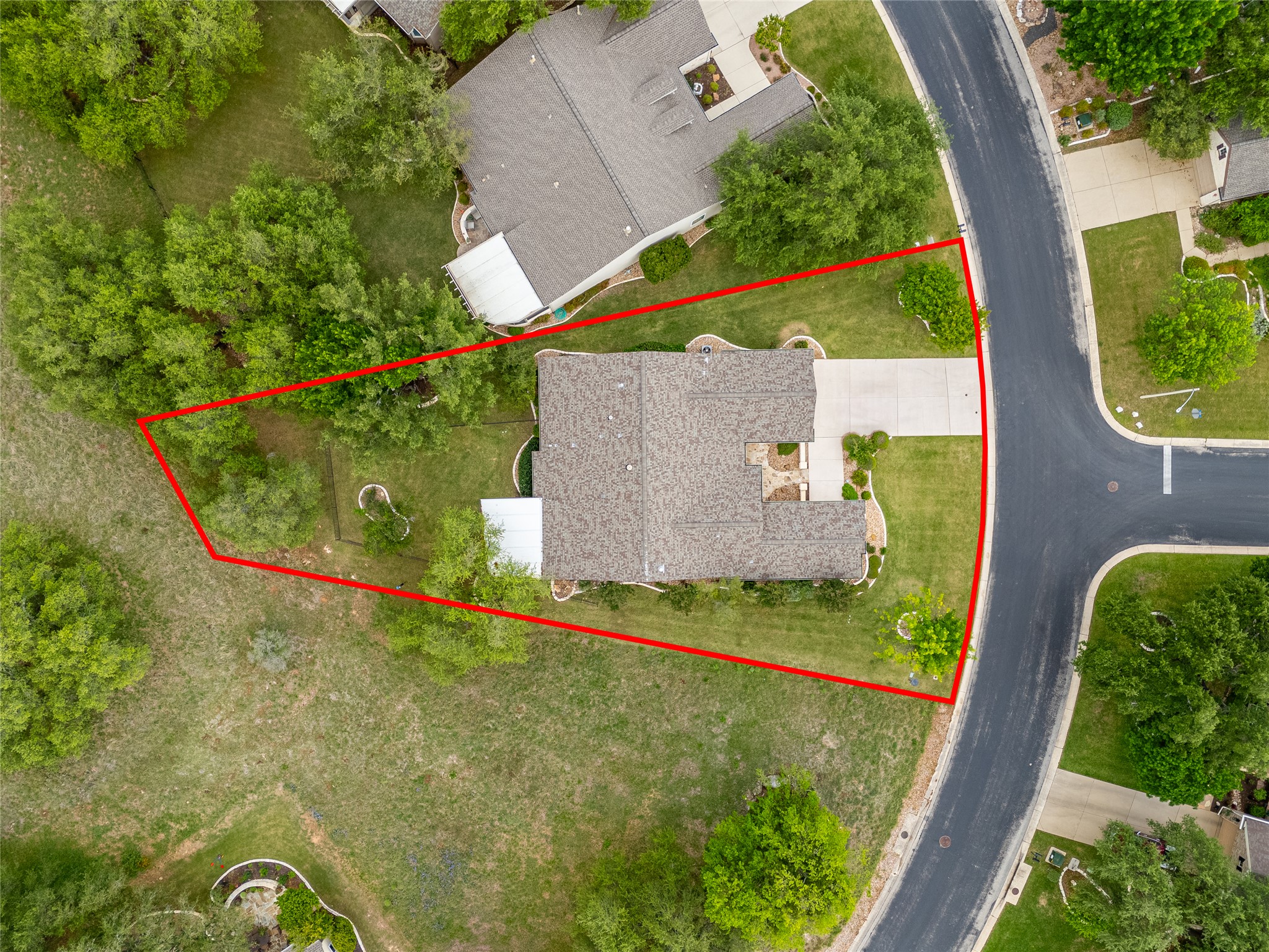 214 Summit Street Georgetown, TX 78633 - Photo 34 of 38 Aerial view of the property, featuring a gray-roofed home, a paved driveway, and a well-maintained lawn