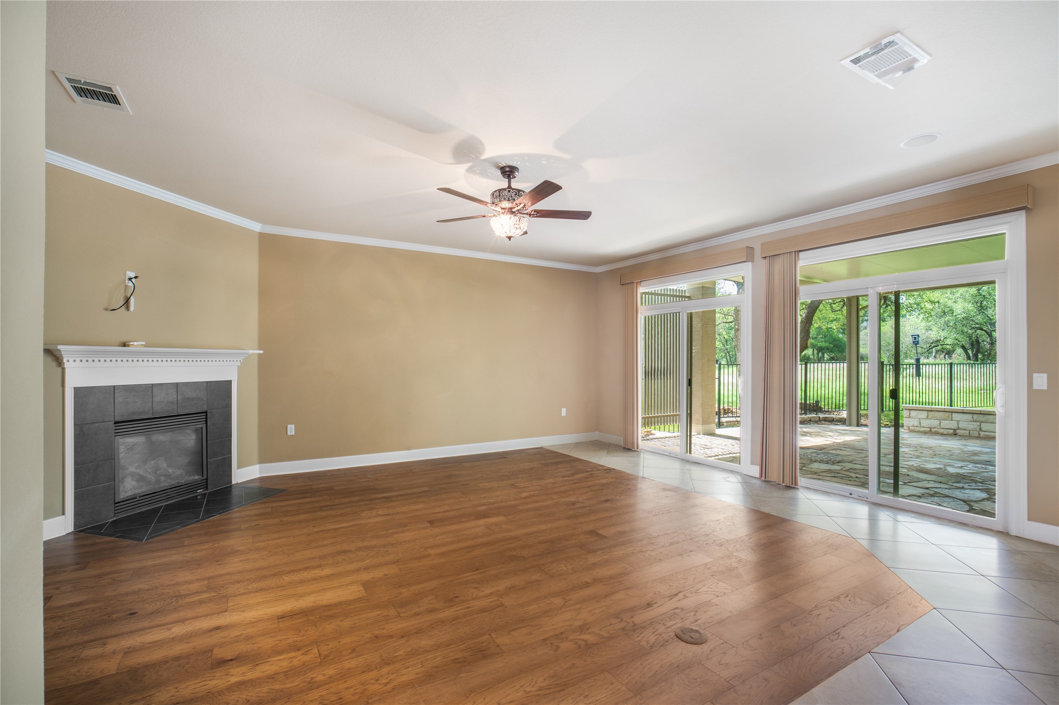 214 Summit Street Georgetown, TX 78633 - Photo 8 of 38 Spacious living area featuring hardwood flooring, a ceiling fan, and a fireplace with a dark tile surround and white mantel
