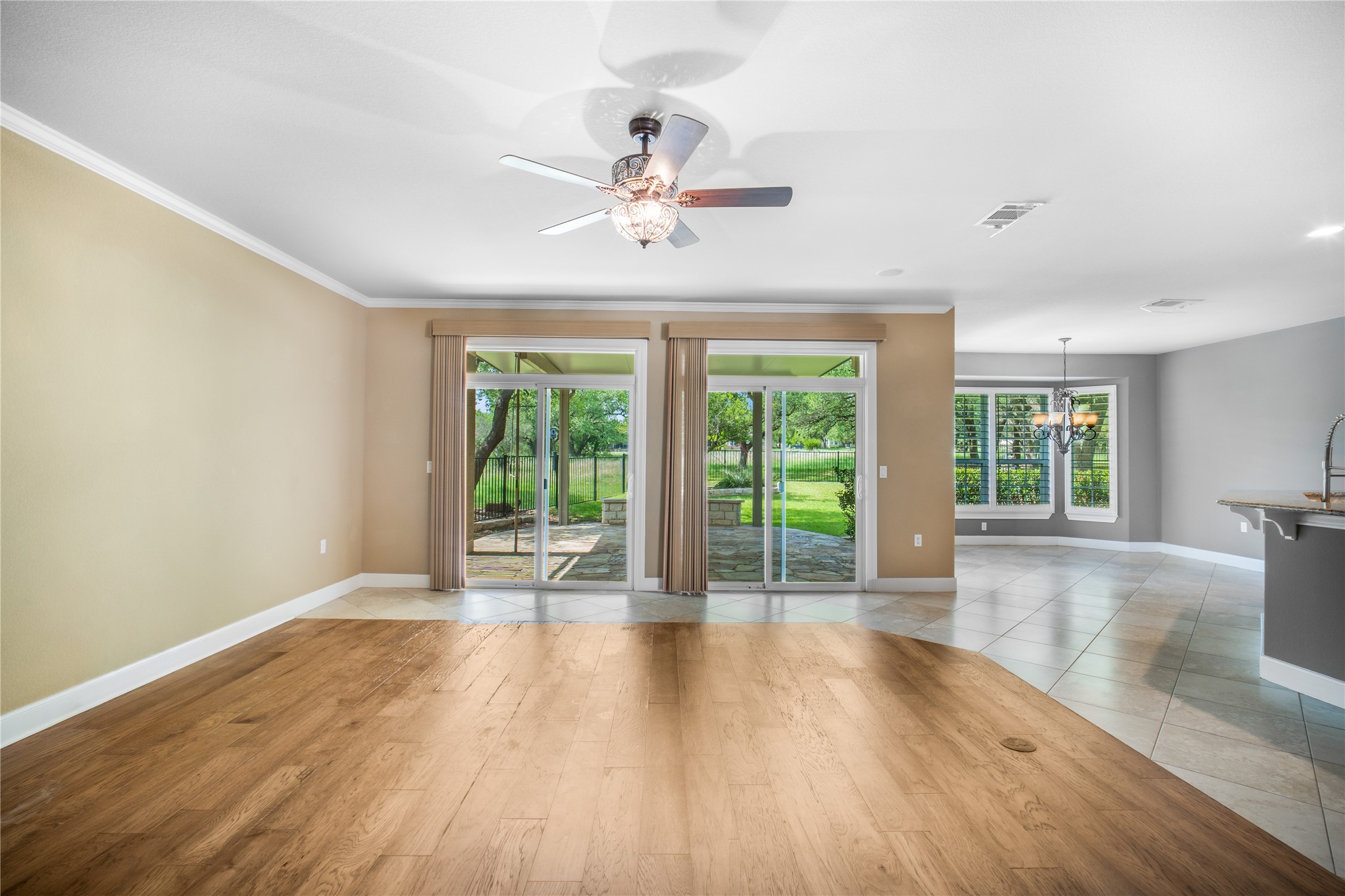 214 Summit Street Georgetown, TX 78633 - Photo 9 of 38 Spacious living area featuring light-toned walls, crown molding, and a combination of hardwood and tiled flooring