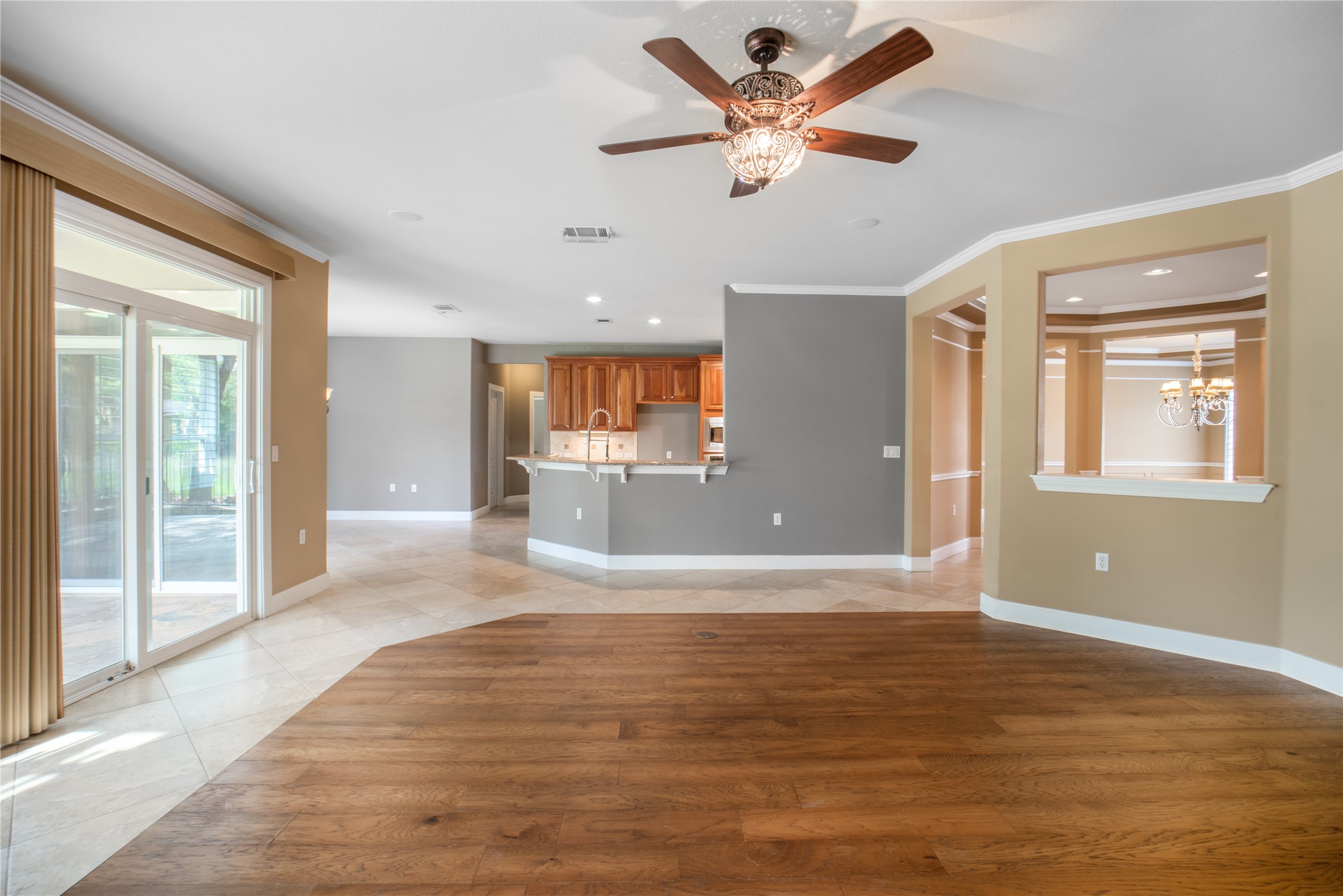 214 Summit Street Georgetown, TX 78633 - Photo 10 of 38 Expansive living area featuring a decorative ceiling fan, a combination of hardwood and tiled flooring, and sliding glass doors leading to the exterior