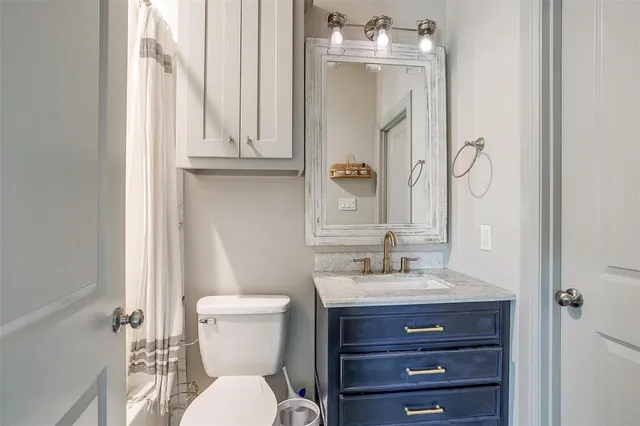 a bathroom with a toilet a sink and mirror