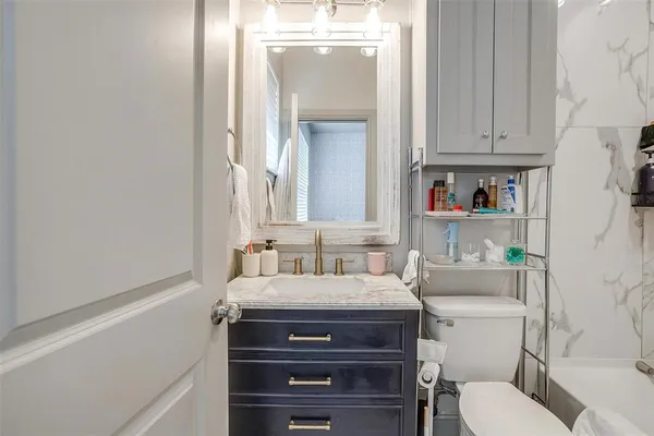 a bathroom with a sink vanity mirror and toilet