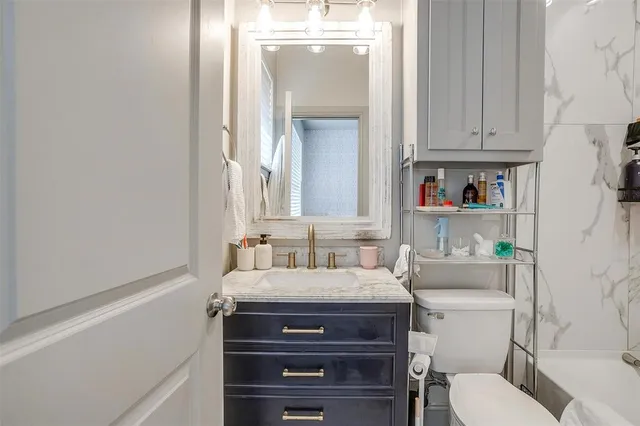 a bathroom with a sink vanity mirror and toilet