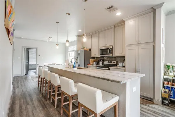 a kitchen with stainless steel appliances granite countertop a table chairs microwave and sink