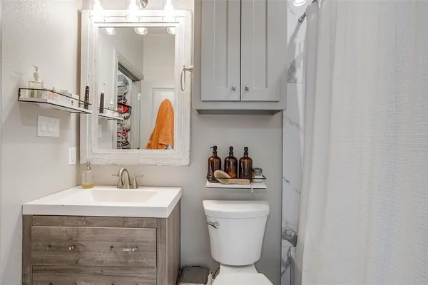 a bathroom with a toilet sink and mirror