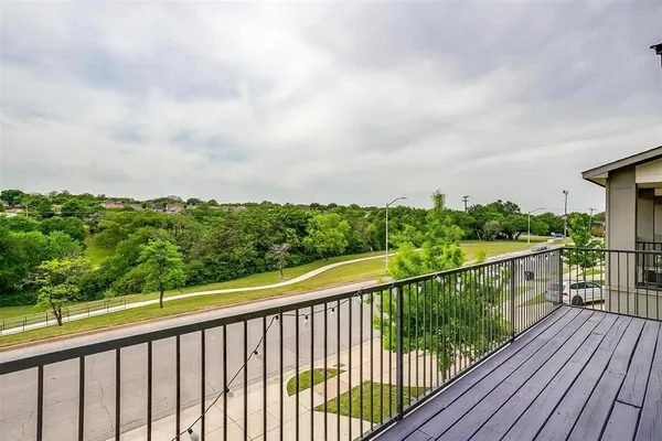 a balcony with wooden floor and fence