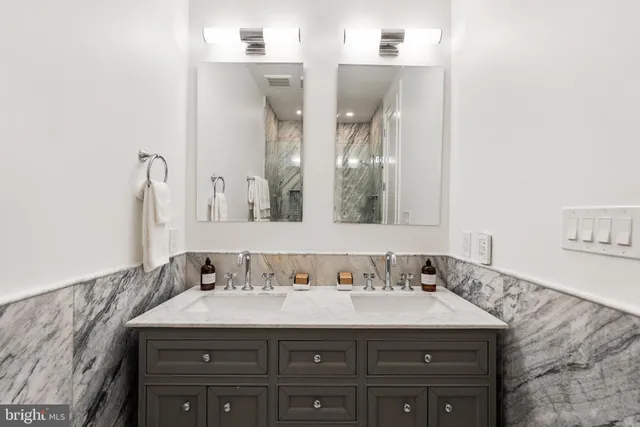 a bathroom with a granite countertop sink and a mirror