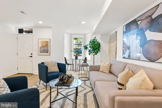 a living room with furniture and a potted plant