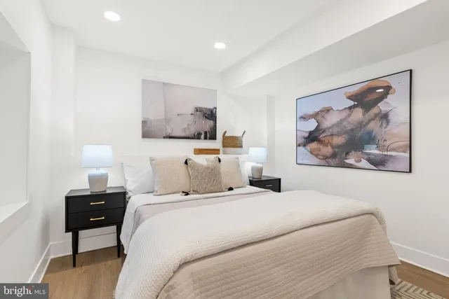 a bedroom with a bed and a painting on the wall