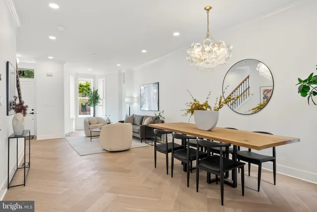 a view of a dining room with furniture a chandelier and wooden floor