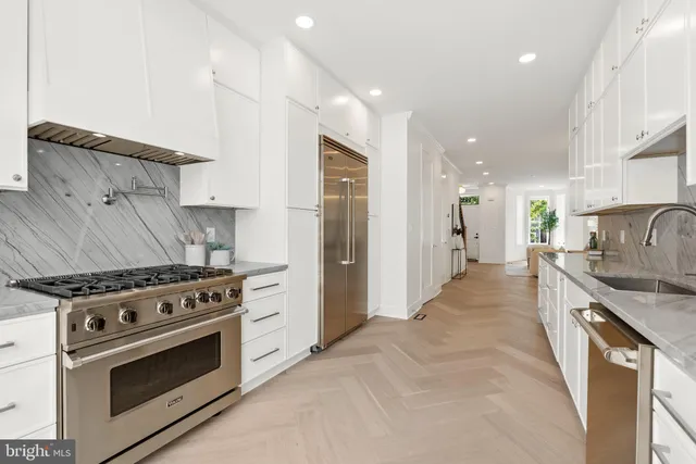 a kitchen with stainless steel appliances a stove a sink and a refrigerator