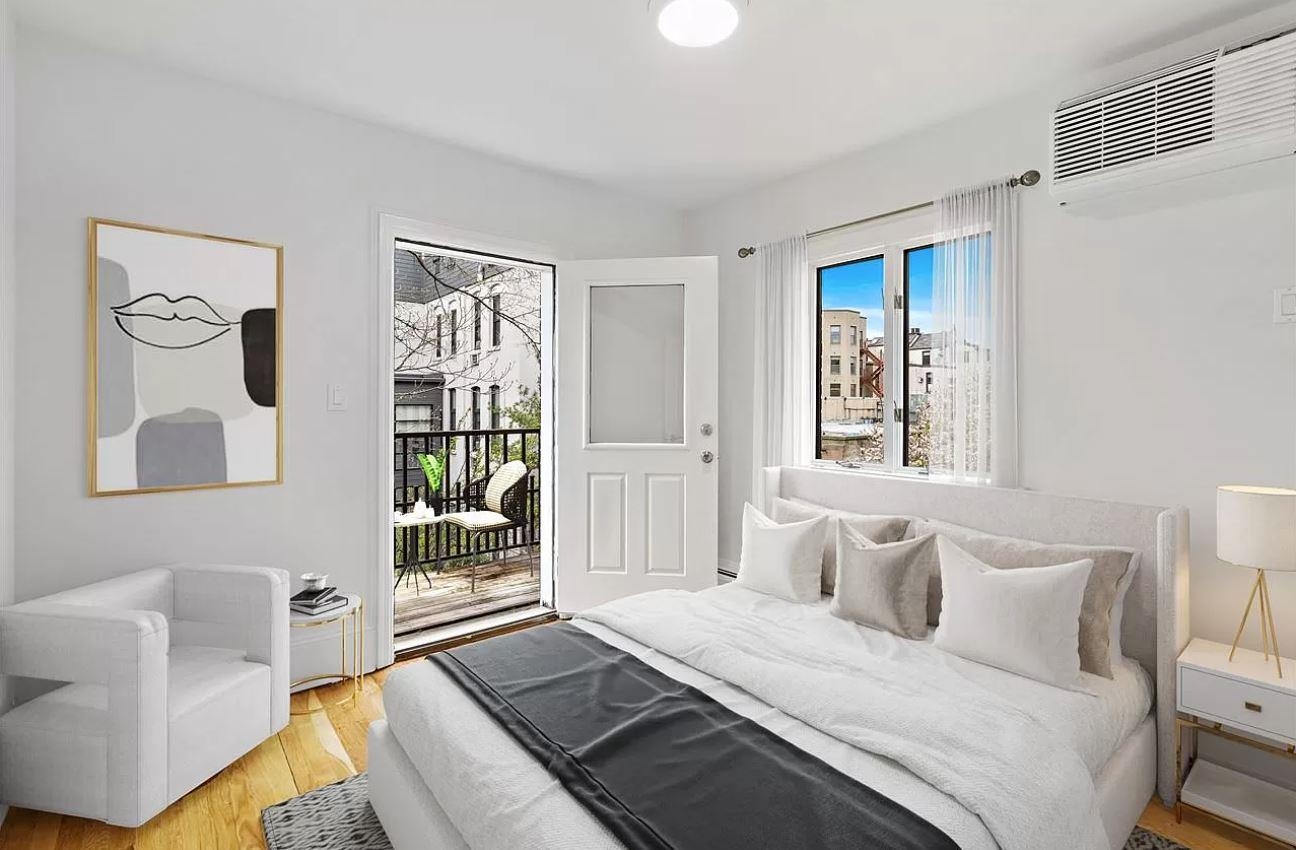 712 Hudson Street Hoboken, NJ 07030 - Photo 10 of 16 a bedroom with a bed and glass window
