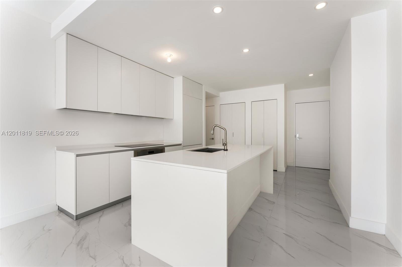 700 Northeast 24th Street, Unit 2504 Miami, FL 33137 - Photo 16 of 52 Modern chef’s kitchen equipped with custom Italian cabinetry, premium Miele appliances, integrated stone countertops, and a waterfall island perfect for entertaining.
