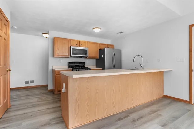 a kitchen with stainless steel appliances a refrigerator sink and microwave