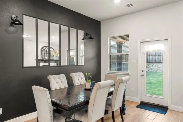 a kitchen with stainless steel appliances kitchen island granite countertop a stove top oven a sink a refrigerator with wooden floors