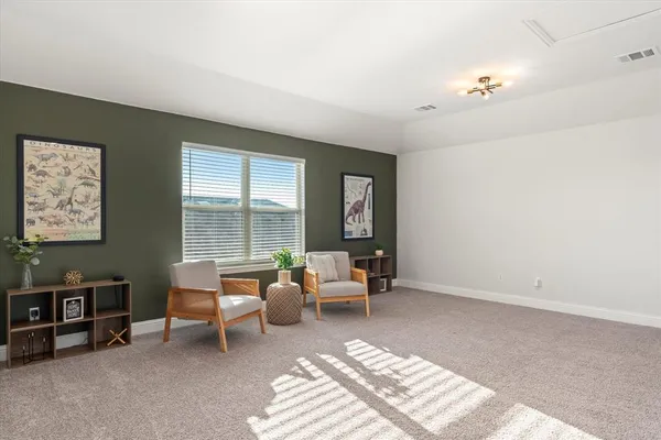 a view of a bedroom with furniture and window