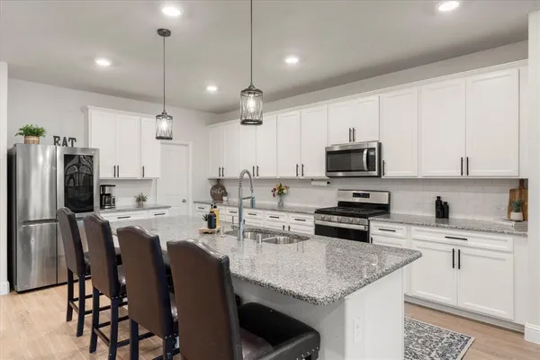 a large kitchen with cabinets table and chairs