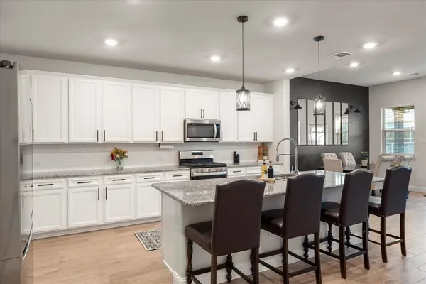a kitchen with kitchen island a sink stove and refrigerator