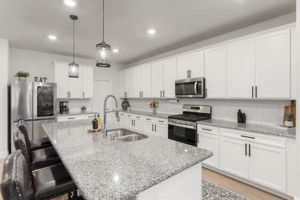 a open kitchen with stainless steel appliances granite countertop a sink stove and refrigerator