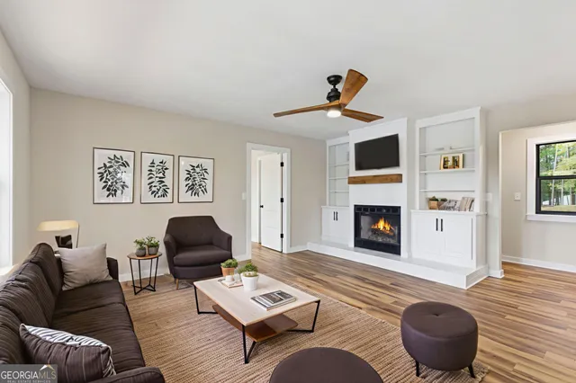a view of a livingroom with a ceiling fan and wooden floor