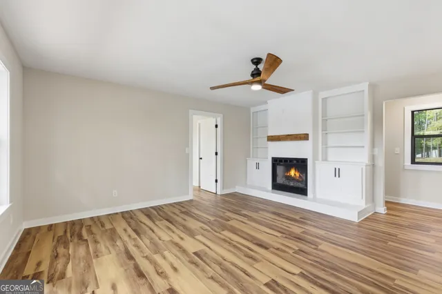 a view of a livingroom with wooden floor and a fireplace