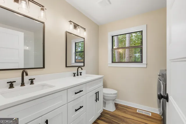 a bathroom with double sink and two mirror