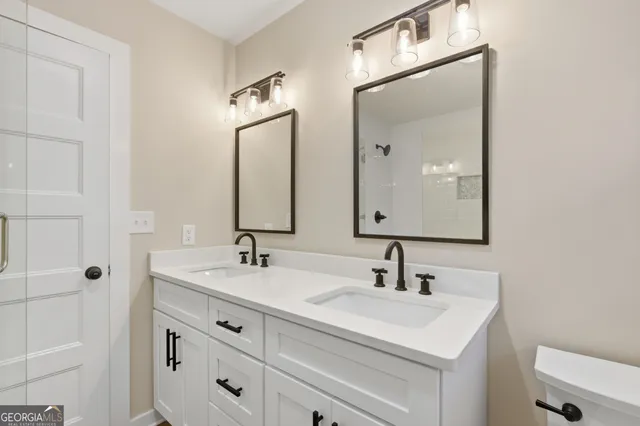 a bathroom with a granite countertop sink toilet and shower