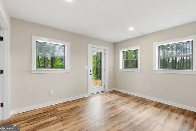 a view of a big room with wooden floor and windows