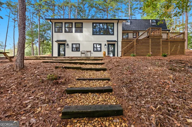 a view of a yard with plants and large trees