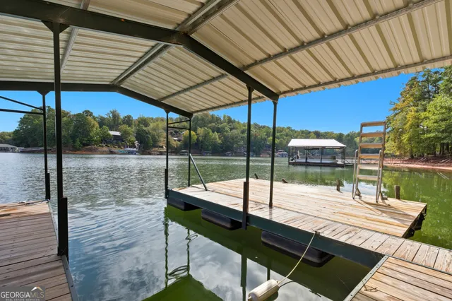 an aerial view of residential house with outdoor space and trees all around