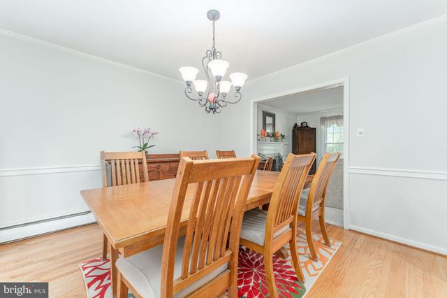 a kitchen with stainless steel appliances granite countertop a stove top oven a sink a dining table and chairs with wooden floor