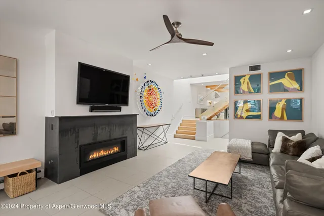 a living room with furniture a flat screen tv and a fireplace