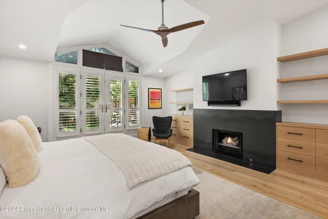 a spacious bedroom with a bed and glass window