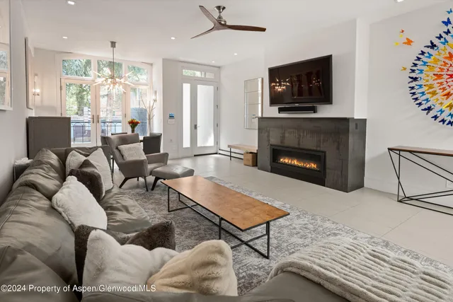 a living room with furniture a flat screen tv and a fireplace