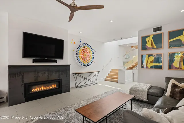 a living room with furniture a flat screen tv and a fireplace